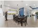 Modern dining room with blue accent wall and stylish light fixture is open to the other living spaces at 8864 Sw 85Th Loop, Ocala, FL 34481