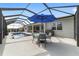 Relax and enjoy the lovely pool in screened-in area with an umbrella-covered table and chairs at 8864 Sw 85Th Loop, Ocala, FL 34481