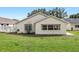 The backyard features green grass, a white fence, and white-trimmed windows for natural light at 9064 Sw 91St Cir, Ocala, FL 34481