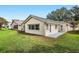 Expansive backyard features green grass, a small patio and exterior doors with white trim at 9064 Sw 91St Cir, Ocala, FL 34481