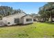 Spacious backyard with lush green grass, mature trees, and white windows that allow for natural light at 9064 Sw 91St Cir, Ocala, FL 34481