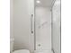 Bathroom featuring a white tile shower with safety bar and glass door at 9064 Sw 91St Cir, Ocala, FL 34481