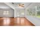 Bright living room featuring hardwood floors, large windows, and a ceiling fan with decorative lighting at 9064 Sw 91St Cir, Ocala, FL 34481