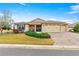 Inviting single-story home featuring a three-car garage, manicured lawn and a driveway made of decorative pavers at 9085 Sw 89Th Loop, Ocala, FL 34481