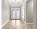 Bright entryway featuring tile flooring, a tray ceiling, and decorative glass double doors at 9085 Sw 89Th Loop, Ocala, FL 34481