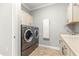 Well-equipped laundry room with modern washer and dryer, sink, and storage cabinets at 9085 Sw 89Th Loop, Ocala, FL 34481