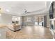 Open living room with tiled floors, tray ceiling, and sliding glass doors to the screened-in patio at 9085 Sw 89Th Loop, Ocala, FL 34481