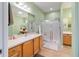 Bathroom featuring neutral tile, wooden vanity, a large mirror and a glass enclosed shower at 9167 Sw 99Th Court Rd, Ocala, FL 34481