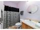 Lavish bathroom with updated vanity, round mirror, and decorative shower curtain at 9167 Sw 99Th Court Rd, Ocala, FL 34481