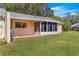 A view of the back of the home, showcasing the well-maintained lawn and screened-in porch at 9335 Sw 85Th Ter # A, Ocala, FL 34481