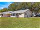 Wide backyard view of the home with a screened-in porch and lush green lawn at 9335 Sw 85Th Ter # A, Ocala, FL 34481