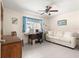 Bright bedroom with a sewing station, a ceiling fan, and a large window at 9335 Sw 85Th Ter # A, Ocala, FL 34481