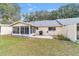 Backyard view featuring a screened lanai, patio, grill, and well-maintained lawn at 9348 Sw 82Nd Ter # C, Ocala, FL 34481