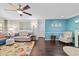 Comfortable living room with hardwood floors, ceiling fan, and eye-catching blue accent wall at 9348 Sw 82Nd Ter # C, Ocala, FL 34481