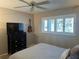 Bedroom with ceiling fan, TV, guitar and plantation shutters on the window at 9535 Sw 85Th Ter # C, Ocala, FL 34481