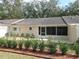 A charming back exterior with screen room, lush landscaping, and wood mulch at 9652 Sw 84Th Ter # C, Ocala, FL 34481