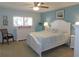 Calming bedroom with a white bed, light blue walls, plantation shutters, and a ceiling fan at 9652 Sw 84Th Ter # C, Ocala, FL 34481