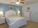 Comfortable bedroom featuring a white bed, soft blue accents, and bright natural light at 9652 Sw 84Th Ter # C, Ocala, FL 34481