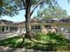 Charming one-story villa with an attached garage, a well-manicured lawn, and a large shade tree in the front yard at 9652 Sw 84Th Ter # C, Ocala, FL 34481