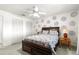 Cozy bedroom features a wooden bed frame, ceiling fan, and unique blue circular patterned wall decals at 9866 Sw 97Th Ln, Ocala, FL 34481