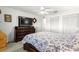 Bedroom boasts a dresser with a TV, ceiling fan, and closet for ample storage space at 9866 Sw 97Th Ln, Ocala, FL 34481