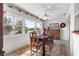 Sunlit dining area with a wooden table, colorful textiles, and neighborhood views at 9866 Sw 97Th Ln, Ocala, FL 34481