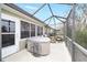 Covered back porch with a hot tub, seating, and screened enclosure for outdoor relaxation at 9983 Sw 90Th Loop, Ocala, FL 34481