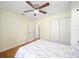 Bright bedroom with a ceiling fan, closet, and a floral-patterned bedspread at 9983 Sw 90Th Loop, Ocala, FL 34481