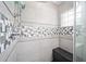 Close-up of the shower with modern tile accents, bench, and clear glass window at 9983 Sw 90Th Loop, Ocala, FL 34481