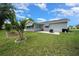 Back exterior view of the home featuring well-maintained landscaping, patio, and lanai at 10821 Sw 87Th Ter, Ocala, FL 34481