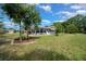 Backyard featuring the exterior of the home with landscaping and well-maintained lawn at 10821 Sw 87Th Ter, Ocala, FL 34481