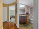 Bathroom with vanity, toilet, and access to a bedroom; wood flooring in the hallway at 10821 Sw 87Th Ter, Ocala, FL 34481