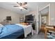 Bedroom with a large TV, ceiling fan, carpet, and a view into another room through an open door at 10821 Sw 87Th Ter, Ocala, FL 34481