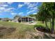 Side exterior view of the home featuring a well-maintained lawn, landscaping, and lanai at 10821 Sw 87Th Ter, Ocala, FL 34481