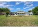 Back exterior view of the home featuring well-maintained lawn, landscaping, and a lanai at 10821 Sw 87Th Ter, Ocala, FL 34481