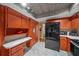 Kitchen view featuring black appliances, orange cabinets and drawers, and white marbled flooring at 10821 Sw 87Th Ter, Ocala, FL 34481