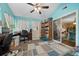 Bright office space with light blue walls, a ceiling fan, and a sliding door that leads to the dining area at 10821 Sw 87Th Ter, Ocala, FL 34481