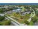 Community aerial view of the clubhouse, pool, parking, and surrounding greenery including golf course and a pond at 11091 Sw 73Rd Ct, Ocala, FL 34476