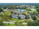 An aerial view of a community clubhouse, pool, and parking area surrounded by green space and mature landscaping at 11091 Sw 73Rd Ct, Ocala, FL 34476