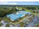 Overhead view of a community with golf course, pool, parking and clubhouse with mature landscaping around the buildings at 11091 Sw 73Rd Ct, Ocala, FL 34476