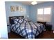 Bedroom features a blue plaid bedspread and shuttered window at 11091 Sw 73Rd Ct, Ocala, FL 34476