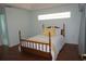 Bedroom with accent window, wood floors, and charming bed at 11091 Sw 73Rd Ct, Ocala, FL 34476