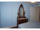 Bedroom showcasing an antique vanity, blue walls, and a window with white shutter-style blinds at 11091 Sw 73Rd Ct, Ocala, FL 34476