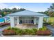 Elegant clubhouse entrance with potted plants, manicured landscaping, and a light blue metal roof at 11091 Sw 73Rd Ct, Ocala, FL 34476