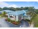 Clubhouse aerial view featuring a metal roof, manicured landscaping, and a paved driveway with easy access at 11091 Sw 73Rd Ct, Ocala, FL 34476