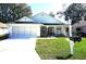 Charming single-story home with a two-car garage, well-maintained lawn, and a cozy front porch at 11091 Sw 73Rd Ct, Ocala, FL 34476