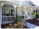 Inviting front porch features decorative columns, comfortable seating, and a landscaped garden at 11091 Sw 73Rd Ct, Ocala, FL 34476