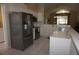 Spacious kitchen with stainless steel appliances, white cabinets, and view of the vaulted living room at 11091 Sw 73Rd Ct, Ocala, FL 34476