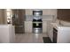 Well-equipped kitchen with stainless steel appliances, white cabinets, and modern tile flooring at 11091 Sw 73Rd Ct, Ocala, FL 34476