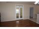 Open living space with laminate flooring, double doors, and an adjacent tiled room at 11091 Sw 73Rd Ct, Ocala, FL 34476